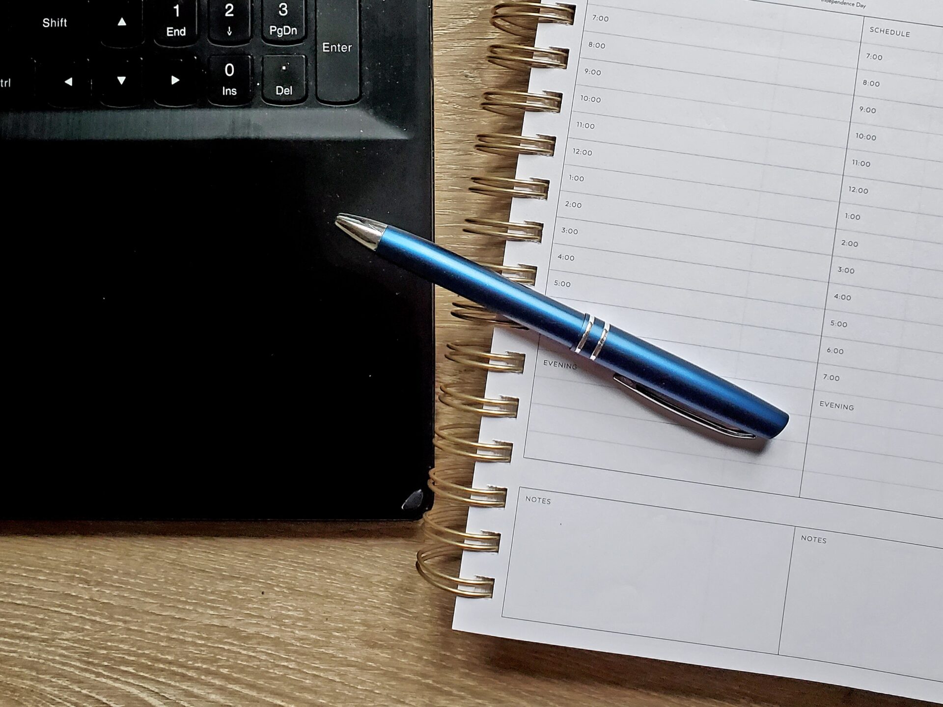 laptop keyboard, pen, and journal