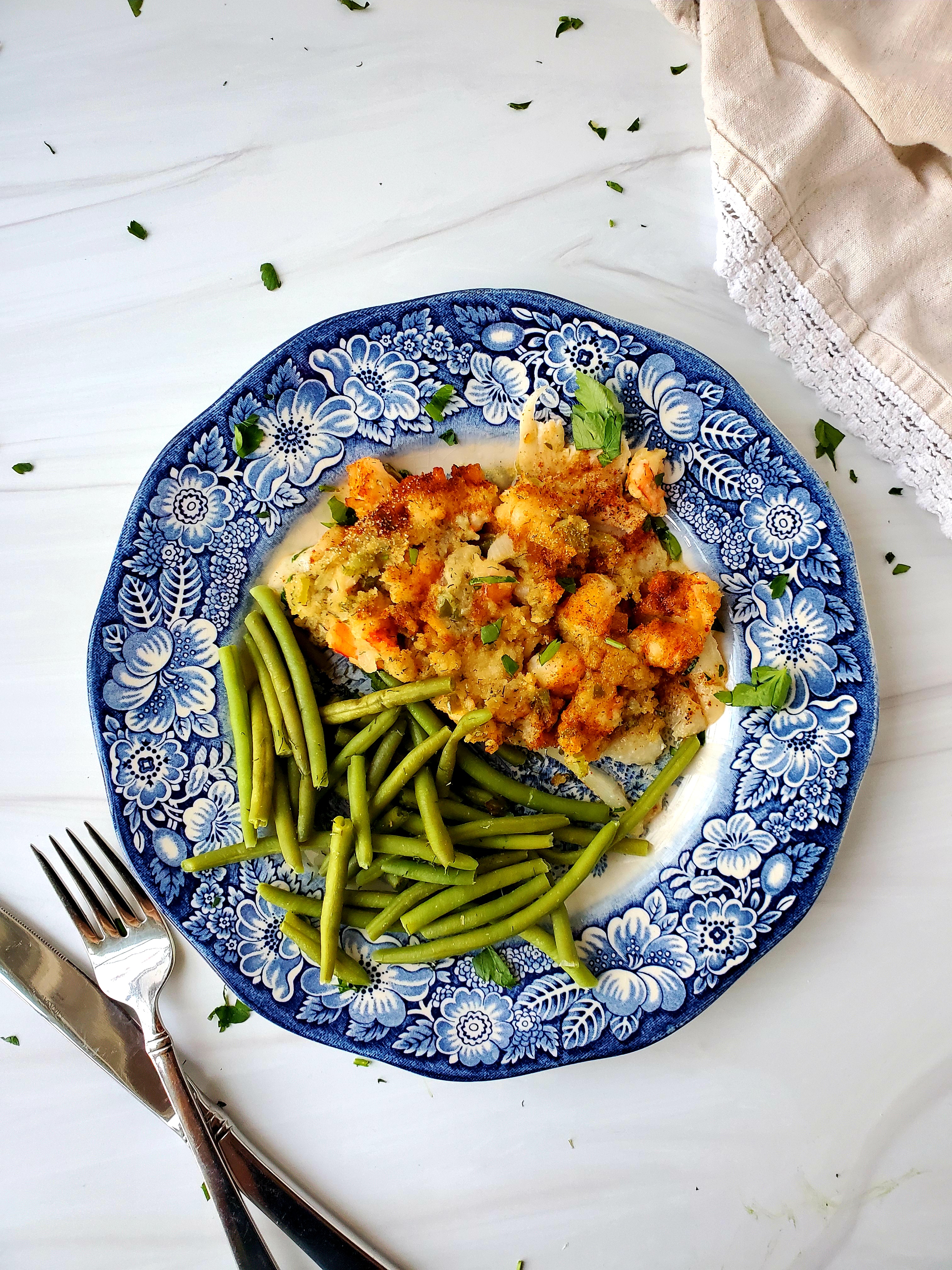 Baked Flounder with Shrimp Stuffing on blue transferware plate with green beans and silverware