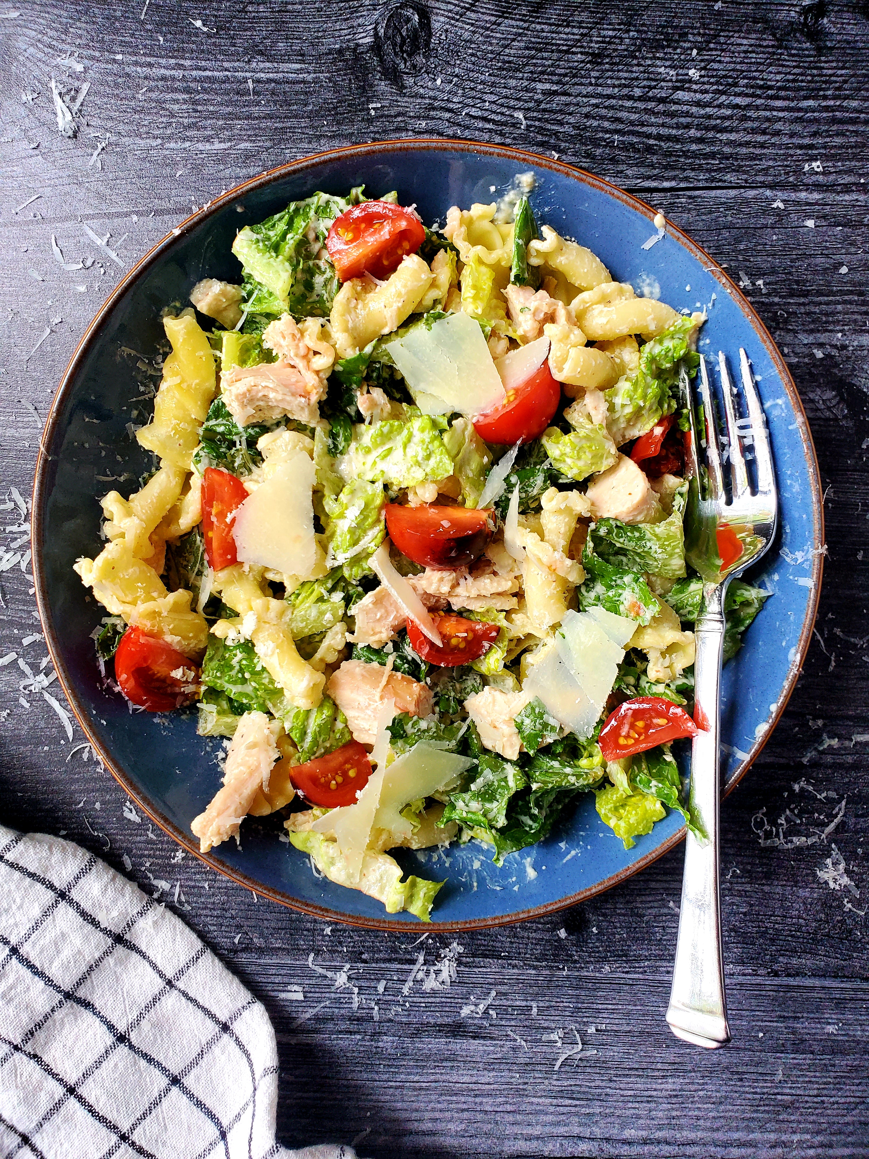 Chicken Caesar Pasta Salad in bowl with fork and napkin