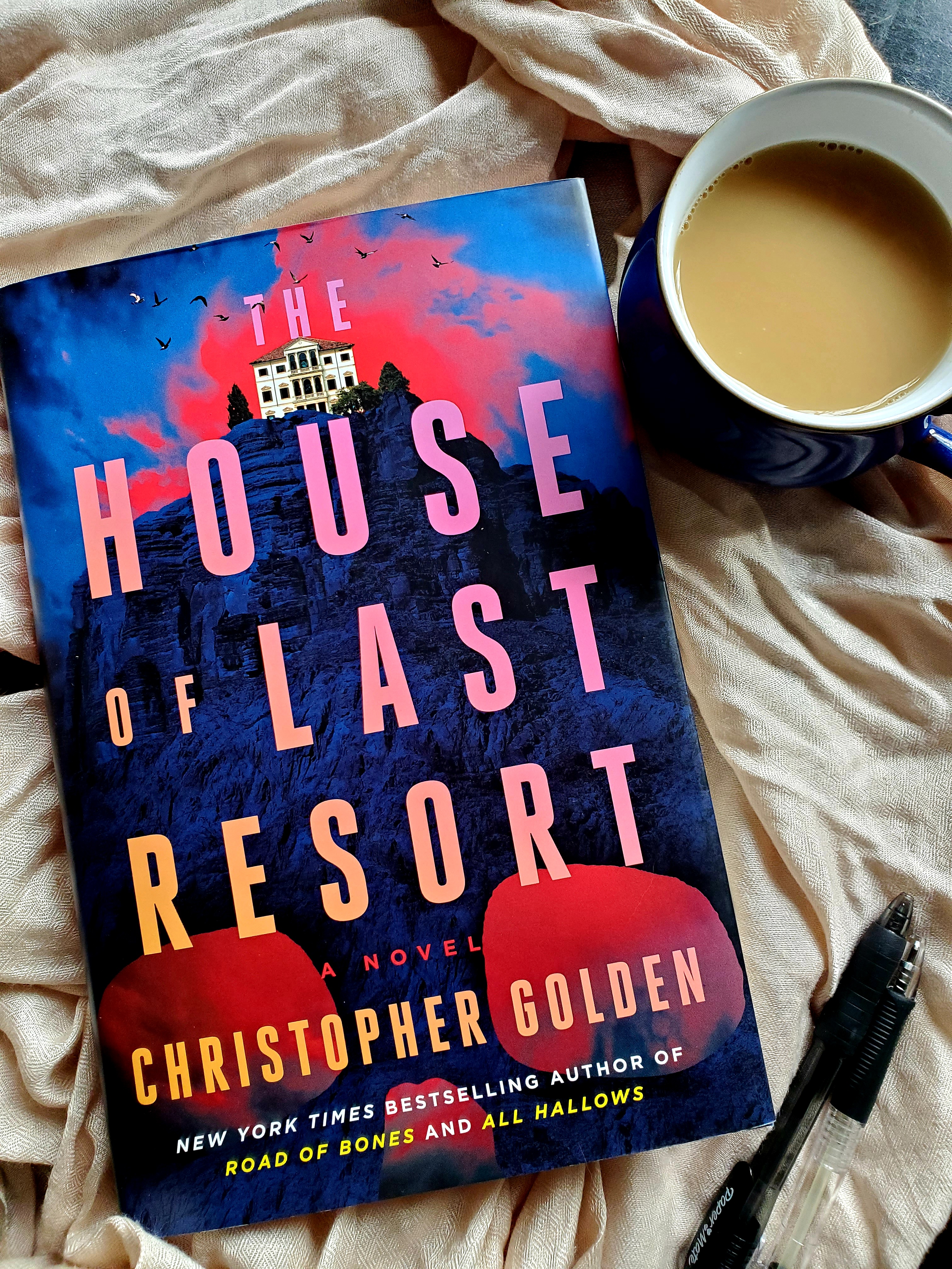 Book cover of THE HOUXSE OF LAST RESORT by Christopher Golden and a mug of tea