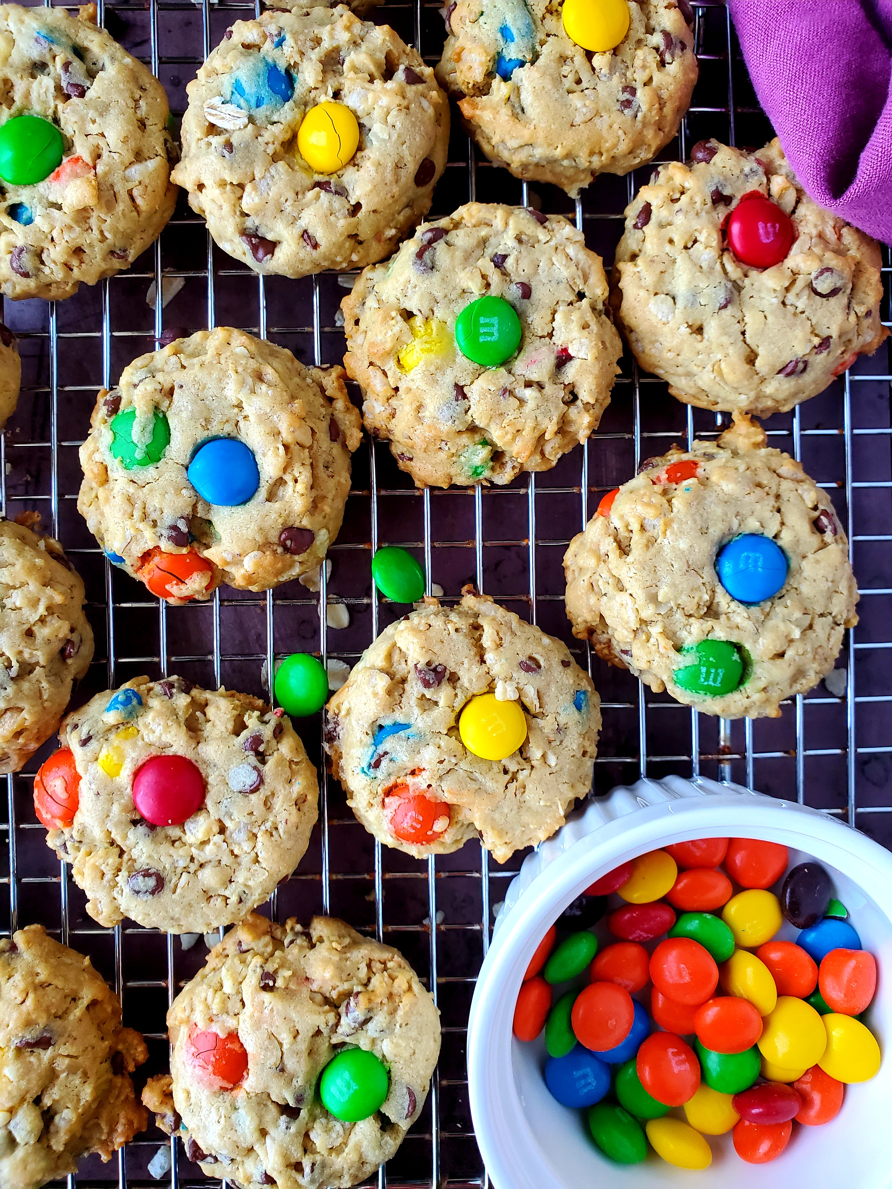 monster cookies on baking sheet with bowl of M&Ms