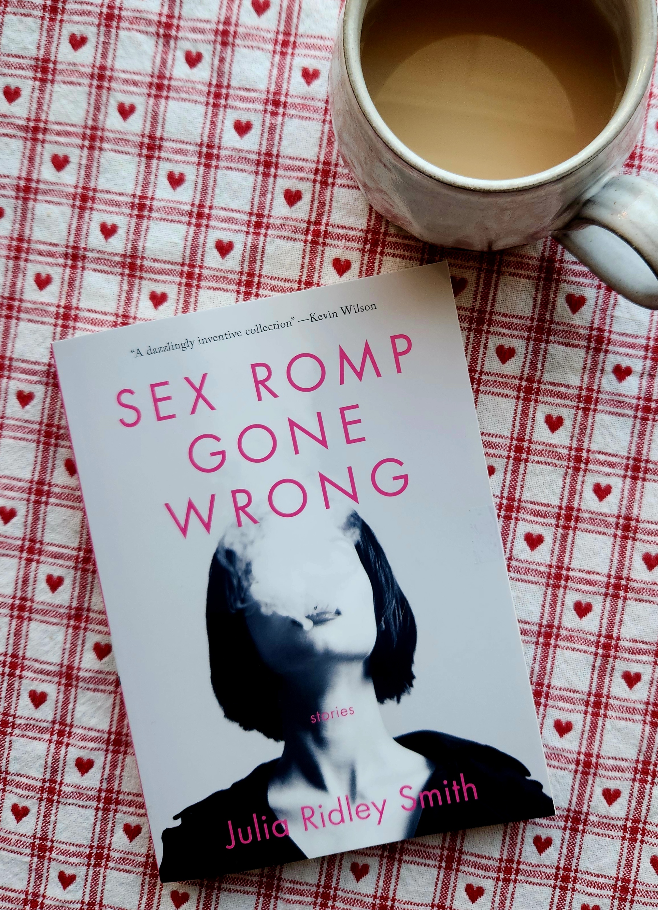 book cover of sex romp gone wrong by julia ridley smith, and a cup of tea
