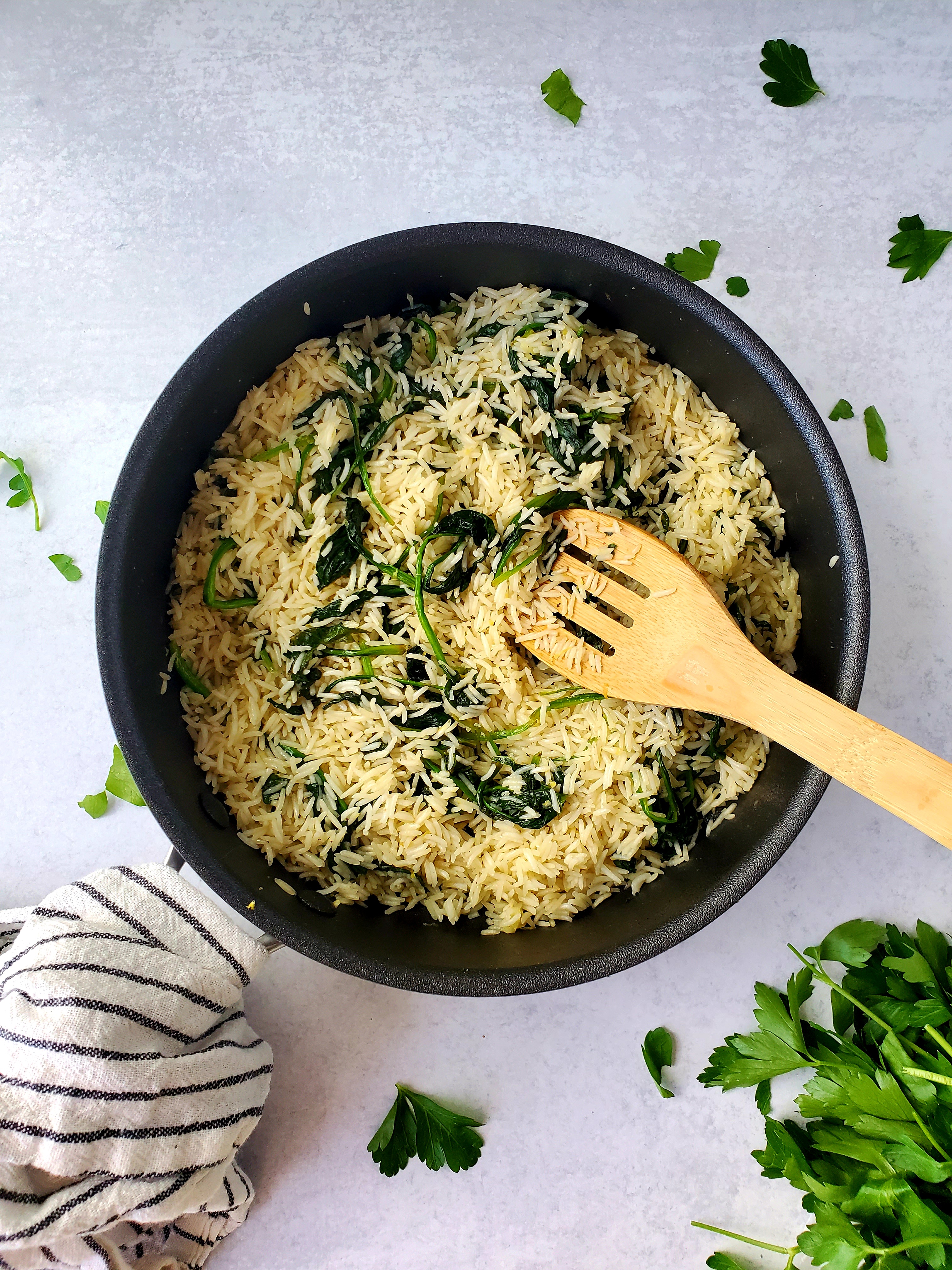 Lemon Spinach Basmati Rice in skillet on replica surfaces cement background
