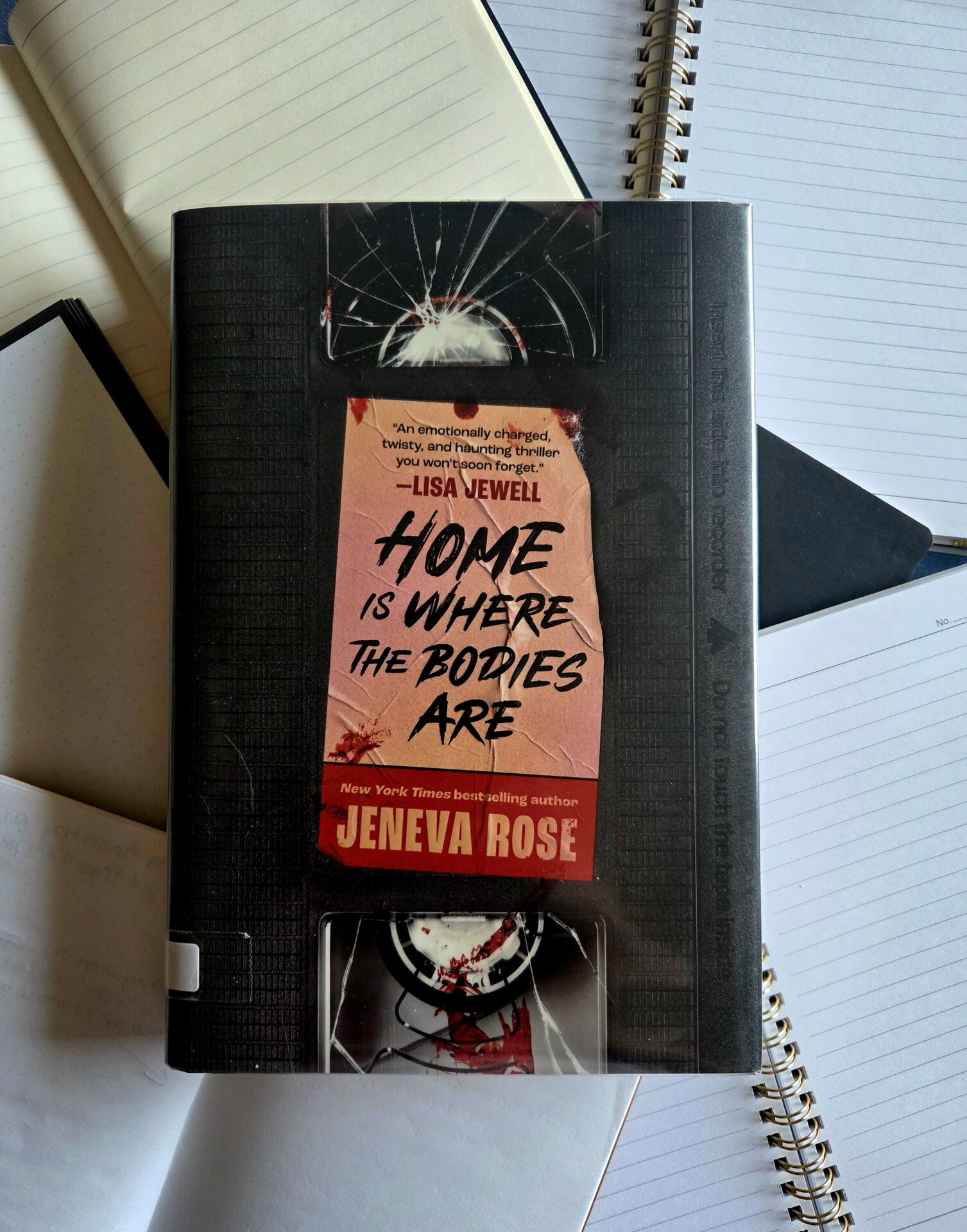 book cover with books of home is where the bodies are by jeneva rose