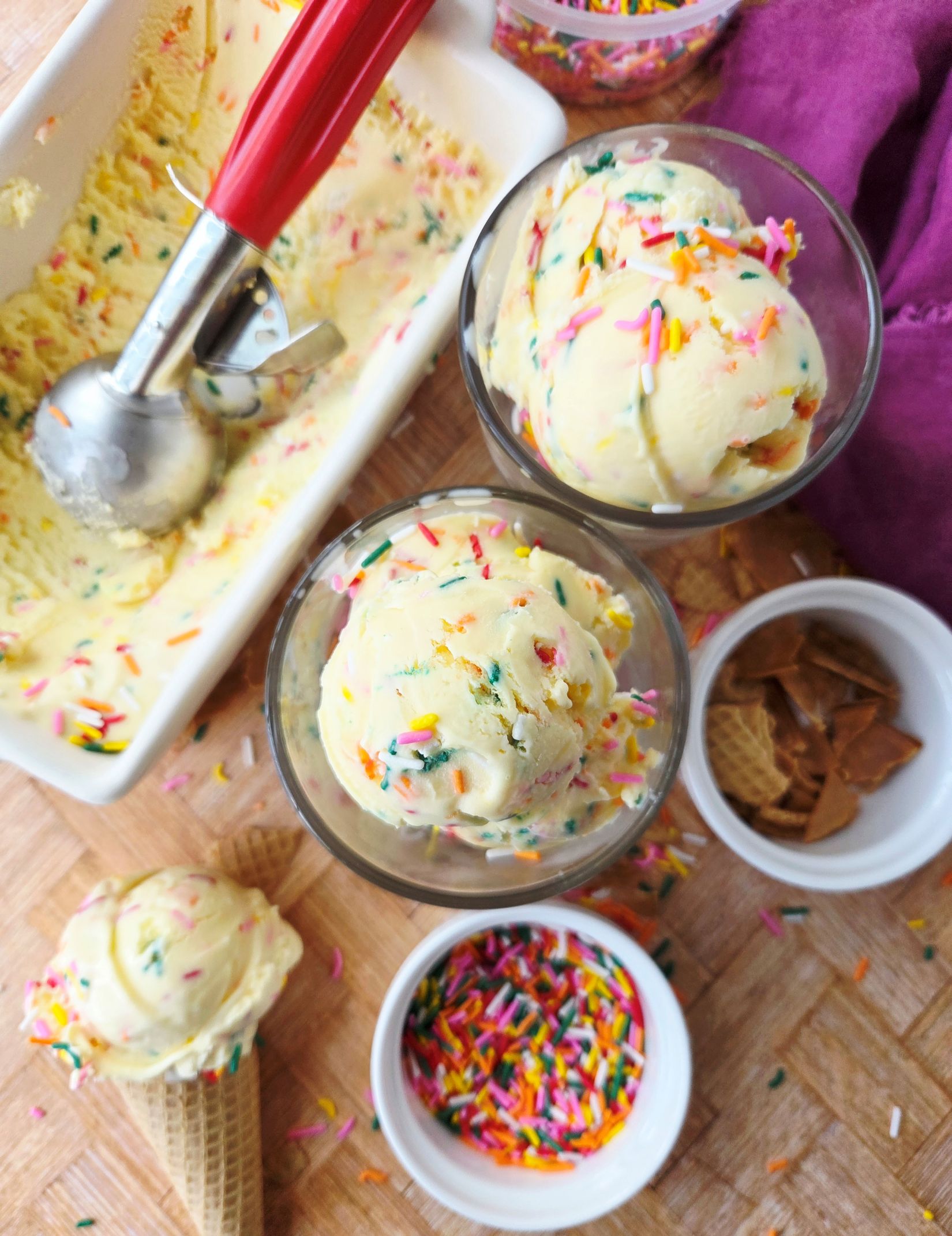 birthday cake ice cream in container, cups, and cones